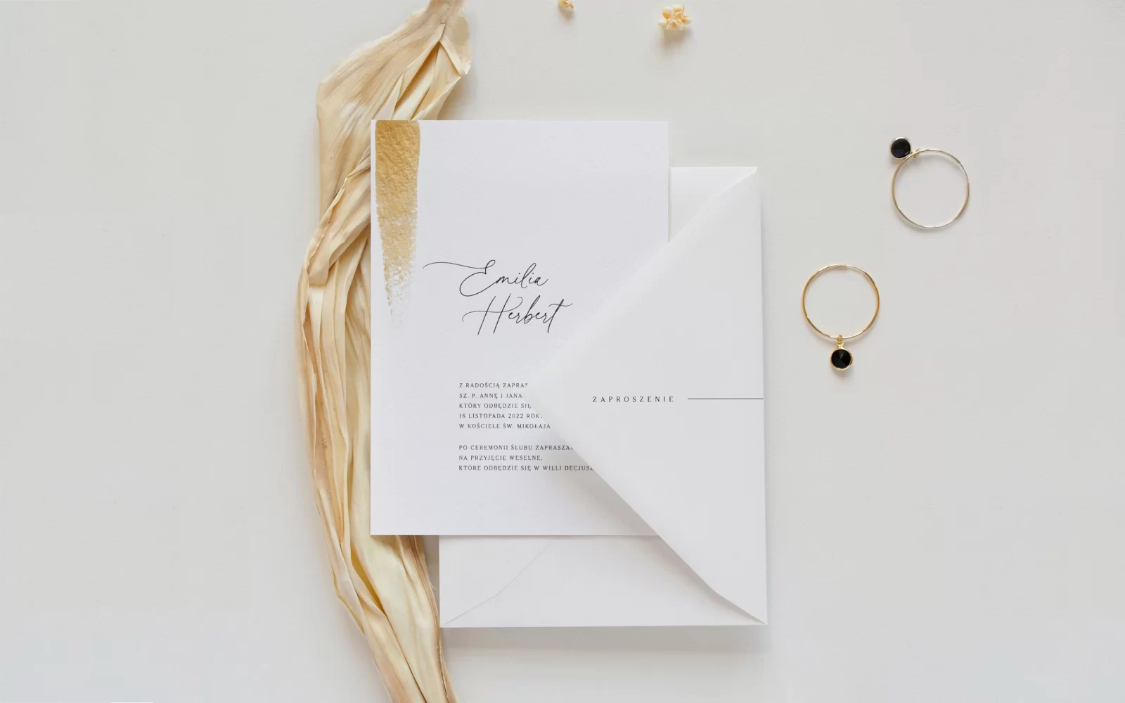 Białe zaproszenia ślubne ze złoceniem