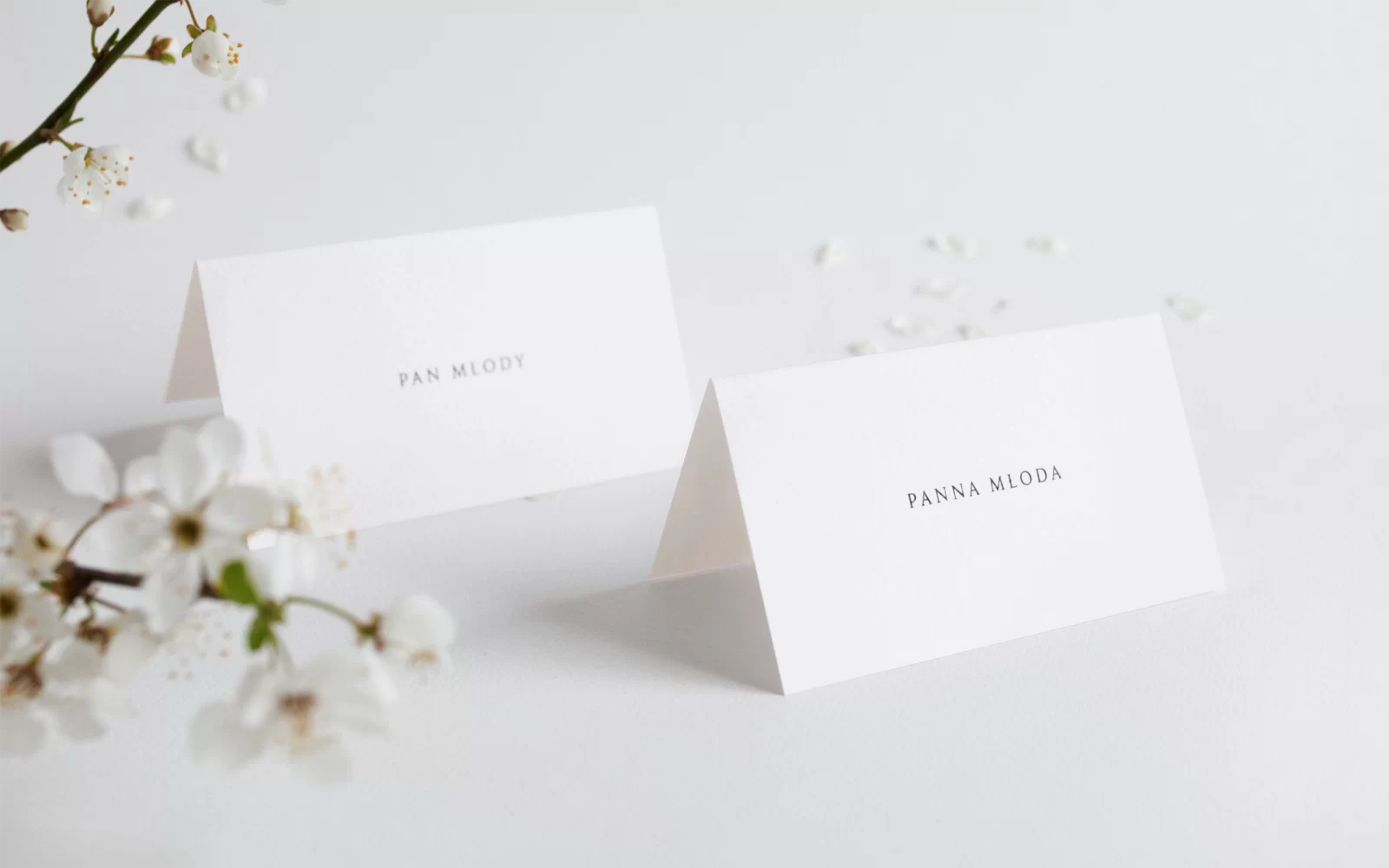 Białe winietki w formie daszka z imionami gości weselnych